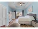 Inviting bedroom with tray ceilings, wood floors, and ample natural light at 1322 Seven Eagles Ct # 301, Reunion, FL 34747