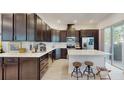 Stylish kitchen featuring dark cabinets, stainless steel appliances, and a large island with seating at 13241 Cormack Ln, Orlando, FL 32827