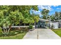 Charming blue home featuring a well-maintained lawn and a driveway, shaded by mature trees at 133 Moss Dr, Debary, FL 32713