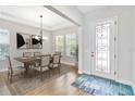 Bright dining room featuring a modern chandelier, large windows, and light wood flooring at 16753 Gullfloss Ter, Winter Garden, FL 34787