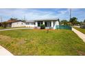 Exterior view of a cozy home with green lawn, walkway, and tidy landscaping on a sunny day at 1831 Aaron Ave, Orlando, FL 32811