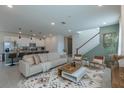 Open-concept living area flows into a sleek kitchen with bar seating, perfect for entertaining guests at 2004 Fleming Mist Pl, Kissimmee, FL 34747