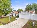 Inviting single-story home featuring a spacious driveway, solar panels, and landscaped front yard at 211 Dalton Dr, Kissimmee, FL 34758