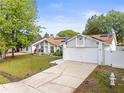 Inviting single-story home featuring a spacious driveway, solar panels, and landscaped front yard at 211 Dalton Dr, Kissimmee, FL 34758