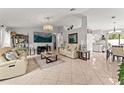 Open-concept living room featuring tile floors, neutral paint, modern decor, and plenty of natural light at 211 Dalton Dr, Kissimmee, FL 34758