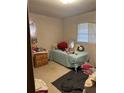 Modest bedroom featuring a twin bed, side table, and natural light at 2207 Virginia Ave, Eustis, FL 32726