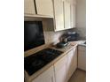 Functional kitchen with white cabinets, tile backsplash, and an electric stovetop at 2207 Virginia Ave, Eustis, FL 32726