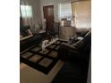 Cozy living room with dark leather furniture and a patterned area rug at 2207 Virginia Ave, Eustis, FL 32726