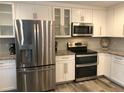 Close-up of a kitchen with stainless steel appliances, white cabinets, and granite countertops, showcasing modern finishes at 222 Georgetown Dr # C, Casselberry, FL 32707