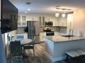 Bright kitchen with white cabinets, stainless steel appliances, and a granite island complemented by a cozy breakfast nook at 222 Georgetown Dr # C, Casselberry, FL 32707