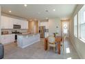 Open concept kitchen with white cabinetry, stainless steel appliances, and a dining area at 2285 Mystic Maze Ln, Clermont, FL 34715