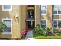 Exterior shot of building entrance, with address sign, colorful landscaping, and natural lighting at 2781 Almaton Loop # 404, Kissimmee, FL 34747
