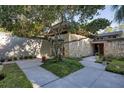 Unique home exterior showcasing stone accents and a well-manicured front yard with mature trees at 320 Mary Jess Rd, Orlando, FL 32839
