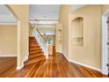 Bright entryway with polished hardwood floors and a staircase leading to the upper level at 353 Meadow Beauty Ter, Sanford, FL 32771