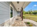 Covered walkway showcasing stone accents, brick pavers, and a view of the well-maintained lawn at 3550 Kaiser Ave, St Cloud, FL 34772
