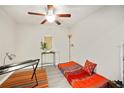 Minimalist bedroom featuring a comfortable futon, stylish desk, and modern ceiling fan at 380 Carina Cir, Sanford, FL 32773