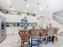 Bright kitchen featuring white cabinetry, stainless steel appliances, a granite island, and decorative bar stools at 4098 Lana Ave, Davenport, FL 33897