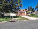Well-maintained front yard with lush lawn, mature trees, and charming landscaping at 450 Morning Blossom Ln, Oviedo, FL 32765