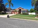 Well-maintained front yard with lush lawn, mature trees, and charming landscaping at 450 Morning Blossom Ln, Oviedo, FL 32765