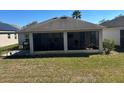 Screened-in patio with outdoor seating area, adjacent to a well-maintained yard and grill at 457 Bridgeford Crossing Blvd, Davenport, FL 33837