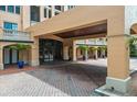 Covered entrance showing brick paving, large glass doors, and tropical planters at 501 Mirasol Cir # 519, Celebration, FL 34747