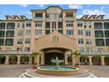 Elegant exterior of a condominium building featuring a water fountain and manicured landscaping at 501 Mirasol Cir # 519, Celebration, FL 34747