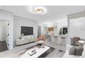 Bright, open-concept living room featuring modern furnishings and sleek lighting fixtures at 6685 Queens Borough Ave # 202, Orlando, FL 32835