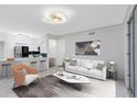 Modern living room with stylish decor, white sofa, and a view of the kitchen area at 6685 Queens Borough Ave # 202, Orlando, FL 32835