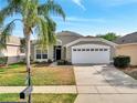 Attractive single-story home boasts a well-kept lawn, vibrant landscaping, and a functional two-car garage for convenience at 8118 Fan Palm Way, Kissimmee, FL 34747