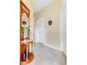 Inviting hallway with neutral walls, tiled floors, and a charming wooden hall tree with ornate mirror and coat hooks at 9044 Azalea Sands Ln # 4011, Davenport, FL 33896