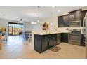 Open concept kitchen with dark cabinetry, stainless steel appliances, quartz countertops, and seamlessly flowing to living area at 9044 Azalea Sands Ln # 4011, Davenport, FL 33896