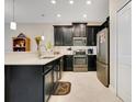 Modern kitchen featuring stainless steel appliances, quartz countertops, dark cabinets, and tiled floor at 9044 Azalea Sands Ln # 4011, Davenport, FL 33896