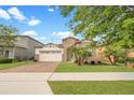 Charming home featuring a brick driveway, stone accents, and well-manicured landscaping at 9188 Chandler Dr, Groveland, FL 34736