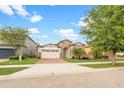 Inviting home with a manicured lawn and mature trees, showcasing curb appeal at 9188 Chandler Dr, Groveland, FL 34736