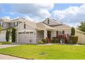A well-maintained single-Gathering home boasts a two-car garage, green lawn, and beautiful landscaping at 951 Cutke Rd, St Cloud, FL 34771