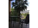 Balcony showcasing sitting area with table and chairs, overlooking a green space and parking lot at 12539 Floridays Resort Dr 411 # 411D, Orlando, FL 32821