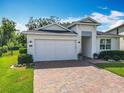 Home featuring a well-manicured lawn, brick driveway, and a 2-car garage at 3631 Arbordale Loop, Sanford, FL 32771