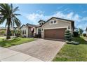 Attractive front exterior featuring a paver driveway, manicured lawn and lush landscaping at 5004 Hartwell Ct, St Cloud, FL 34771