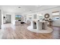 Bright open-concept living and dining area with wood floors, modern lighting, and comfortable seating at 10254 Beechwood Ln, Orlando, FL 32832