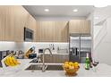 Bright kitchen featuring sleek countertops, stainless steel appliances, and modern wood cabinetry at 17407 Hidden Forest Dr, Clermont, FL 34714