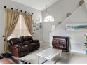 A spacious living room boasts a dramatic staircase, large windows, and stylish decor at 2832 Risser Ave, Orlando, FL 32812
