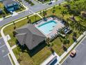 Aerial view of a community pool featuring ample seating and a surrounding green space at 4012 Meandering Bay Dr, Apopka, FL 32712