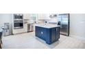 Modern kitchen features stainless steel appliances, white cabinets, and a stylish navy-blue island at 4012 Meandering Bay Dr, Apopka, FL 32712