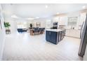 Open floor plan showcases a modern kitchen with large island, dining area, and bright living space at 4012 Meandering Bay Dr, Apopka, FL 32712