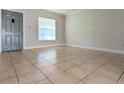 Spacious living room with tile floors, a window offering natural light, and neutral wall paint at 479 Little Aspen Ct, Ocoee, FL 34761