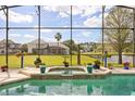 Screened pool area with a waterfall feature and a view of the backyard at 10664 Emerald Chase Dr, Orlando, FL 32836