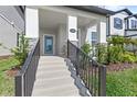 Inviting home entrance with well-kept concrete steps, a sleek black railing, and a charming glass-paneled front door at 12067 Eastmoor Dr, Winter Garden, FL 34787