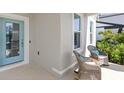 Cozy front porch featuring two wicker rocking chairs with blue pillows next to a lovely, glass-paneled front door at 12067 Eastmoor Dr, Winter Garden, FL 34787