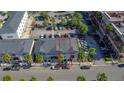 Aerial view of townhome surrounded by parking, palm trees, and nearby commercial development at 12955 Cats Claw Ln, Orlando, FL 32828