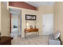 Welcoming foyer featuring neutral tile floors, high ceilings, and a charming entry table with decor at 13416 Greenpointe Dr, Orlando, FL 32824